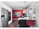 Modern kitchen features stainless steel appliances, a breakfast bar, and a vibrant red accent wall at 415 Lamar St, Lakewood, CO 80226