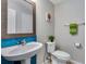 Charming powder bath featuring vibrant blue tile, a decorative mirror, and modern fixtures at 5503 Fullerton Cir, Highlands Ranch, CO 80130