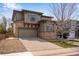 Beautiful two-story home featuring stone accents, a well-kept lawn, and an attached two-car garage at 5503 Fullerton Cir, Highlands Ranch, CO 80130