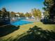 Community tennis court in a fenced area surrounded by mature trees and manicured grass at 14413 E Jewell Ave # 201, Aurora, CO 80012