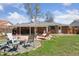 Spacious backyard featuring stone patio, outdoor seating, mature trees, and lush lawn at 269 Beryl Way, Broomfield, CO 80020