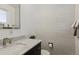 Modern half bathroom with wood paneling, marble countertop, and brushed nickel fixtures at 269 Beryl Way, Broomfield, CO 80020