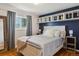 Comfortable bedroom with a large window, wood floors, stylish furnishings, and a blue accent wall at 269 Beryl Way, Broomfield, CO 80020