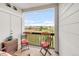 Charming balcony with chairs, pillows, and view of a green space at 8944 Fox Dr # 203, Thornton, CO 80260