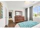 Bright bedroom featuring a dresser, hardwood floors, and a comfortable bed with stylish throw pillows at 8944 Fox Dr # 203, Thornton, CO 80260