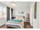 Bright bedroom featuring a chandelier, modern gray walls, and a comfortable bed with stylish throw pillows at 8944 Fox Dr # 203, Thornton, CO 80260