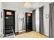 Bedroom featuring dark wood floors, stylish black bookshelves, a full-length mirror, and a crystal chandelier at 8944 Fox Dr # 203, Thornton, CO 80260