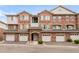 Charming townhouse featuring red brick, individual garages, and well-maintained landscaping at 8944 Fox Dr # 203, Thornton, CO 80260