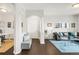 Bright foyer with dark wood floors, bench seating, and arched doorways leading to the living spaces at 8944 Fox Dr # 203, Thornton, CO 80260