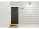 Close-up of a black front door with the unit number 203 on a white shiplap wall at 8944 Fox Dr # 203, Thornton, CO 80260