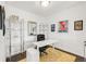 Bright home office with a modern white desk, black office chair, yellow patterned rug, and shelving at 8944 Fox Dr # 203, Thornton, CO 80260