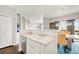 Kitchen area featuring stainless steel dishwasher, white cabinets and countertops, plus a view of the dining room at 8944 Fox Dr # 203, Thornton, CO 80260