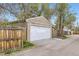 Garage exterior with a white door, adjacent to a wooden fence and concrete driveway at 4425 S Lincoln St, Englewood, CO 80113