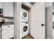 Efficient laundry closet featuring a stacked washer and dryer, maximizing space in this home at 4425 S Lincoln St, Englewood, CO 80113