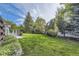 Lush backyard featuring mature trees and landscaped garden beds at 3480 S Dayton St, Denver, CO 80231
