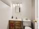 Bathroom vanity with sink, mirror, and toilet with linen cabinet at 3480 S Dayton St, Denver, CO 80231