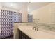 Bathroom featuring dark cabinets, shower with patterned curtain, and a sink with wide mirror at 3480 S Dayton St, Denver, CO 80231