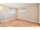 Empty bedroom featuring hardwood floors and two windows with tree views at 3480 S Dayton St, Denver, CO 80231