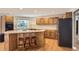 The kitchen has wood cabinets, a tile backsplash, an island, and modern appliances at 3480 S Dayton St, Denver, CO 80231