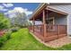 A covered back deck with wood railing overlooks a manicured lawn and garden at 11030 Glacier Park Cir, Parker, CO 80138