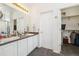 Clean bathroom with double sinks, white cabinetry, and an adjacent walk-in closet at 11030 Glacier Park Cir, Parker, CO 80138