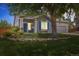 Charming single-Gathering home showcases a well-maintained lawn and a blue front door at 11030 Glacier Park Cir, Parker, CO 80138