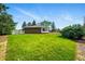 Expansive backyard showcasing a well-maintained lawn and the home's brick exterior under a clear blue sky at 1818 South Union Ct, Lakewood, CO 80228