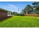Spacious backyard featuring lush green grass, a privacy fence, and the home's exterior, ideal for outdoor activities at 1818 South Union Ct, Lakewood, CO 80228