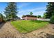 Expansive backyard with a lush lawn, bordered by mature trees and landscaping, showcasing ample outdoor space at 1818 South Union Ct, Lakewood, CO 80228
