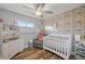 Comfortable Bedroom with crib, changing table, accent wall and wood-look floors at 1818 South Union Ct, Lakewood, CO 80228