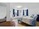 Comfortable bedroom with blue accents, hardwood floors, and natural light from multiple windows at 1818 South Union Ct, Lakewood, CO 80228