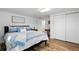 Bright bedroom with wood floors, a large closet, and a comfortable bed adorned with blue and white bedding at 1818 South Union Ct, Lakewood, CO 80228