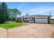 Classic ranch-style home boasting a large driveway and mature landscaping, set beneath a clear sky at 1818 South Union Ct, Lakewood, CO 80228