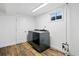 Modern laundry room featuring wood-look floors, a new washer and dryer, and bright natural light at 1818 South Union Ct, Lakewood, CO 80228