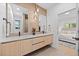 Modern bathroom with double vanity, stylish mirrors, and wood-look accent wall at 974 N Faver Dr, Castle Rock, CO 80109