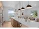 Open-concept kitchen and living space with modern lighting and barstool seating at 974 N Faver Dr, Castle Rock, CO 80109