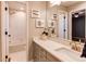 Well-lit bathroom featuring a vanity with art and decor, mirror, and combination shower and tub at 3346 N Josephine St, Denver, CO 80205