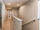 Upstairs hallway with neutral carpet, white railing, and a view of a bedroom at the end at 3346 N Josephine St, Denver, CO 80205