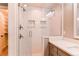 Walk-in shower featuring subway tile, glass door, and built-in shelving for toiletries and decor at 3346 N Josephine St, Denver, CO 80205