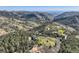 Scenic aerial showcases log home and garage in a vast mountain landscape at 10450 Hondah Dr, Littleton, CO 80127
