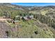 Picturesque aerial view shows log home nestled on a hilltop overlooking a serene valley at 10450 Hondah Dr, Littleton, CO 80127
