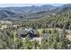 Aerial view of a beautiful log home and separate garage surrounded by lush mountain forests at 10450 Hondah Dr, Littleton, CO 80127