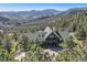 Stunning mountain views surround this log home with a charming green roof at 10450 Hondah Dr, Littleton, CO 80127
