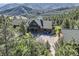 Stunning aerial view of a log home nestled amongst the trees with amazing mountain views at 10450 Hondah Dr, Littleton, CO 80127