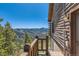 Exterior balcony with mountain view, wood railing, wooden siding, and exterior sconce lighting at 10450 Hondah Dr, Littleton, CO 80127