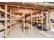 Unfinished basement with wooden shelving, offering ample storage potential at 10450 Hondah Dr, Littleton, CO 80127