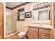 Bright bathroom featuring a glass-enclosed shower, neutral tones, and wood-trimmed window at 10450 Hondah Dr, Littleton, CO 80127