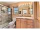 Bathroom with glass-enclosed shower, wood vanity, and ample lighting at 10450 Hondah Dr, Littleton, CO 80127
