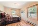 Cozy bedroom with hardwood floors, two windows, and comfortable furnishings at 10450 Hondah Dr, Littleton, CO 80127