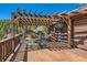 Inviting wooden deck with a pergola, dining set, and peaceful forest views at 10450 Hondah Dr, Littleton, CO 80127